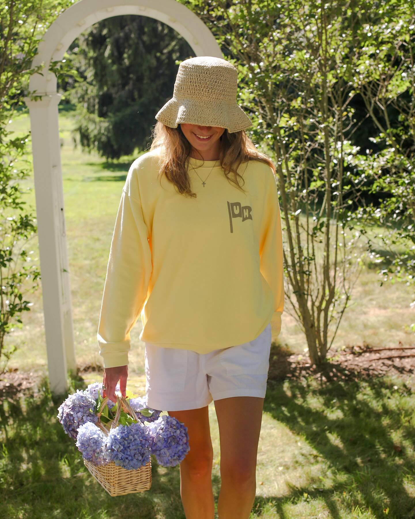 Instagram post with the caption: Our butter UH FLAG crewneck is the ultimate summer vibe 💛 Get r...